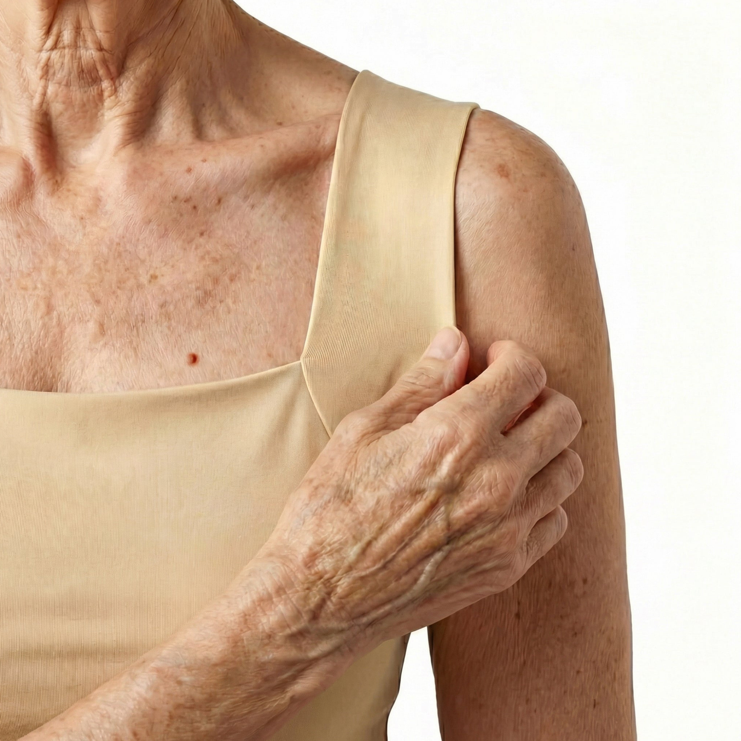 Close-up of an elderly woman's hand holding her shoulder against a white background