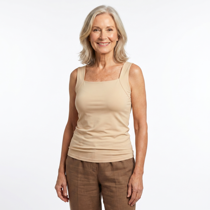 Woman wearing a beige tank top and brown pants on a white background