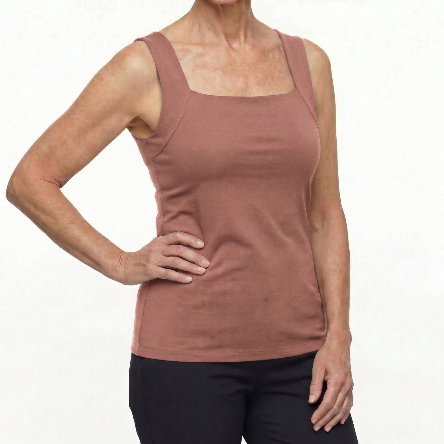 Woman wearing a mauve tank top on a white background
